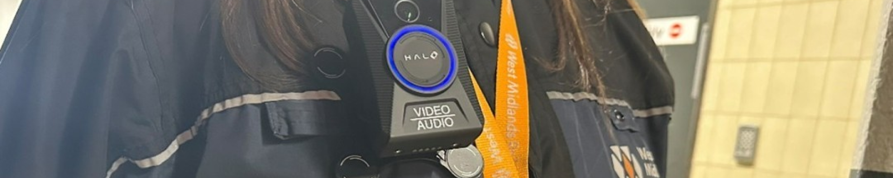 A member of WMR staff wearing a Body Worm Camera on a black jacket. The WMR logo is displayed on the jacket and an orange lanyard is worn. 