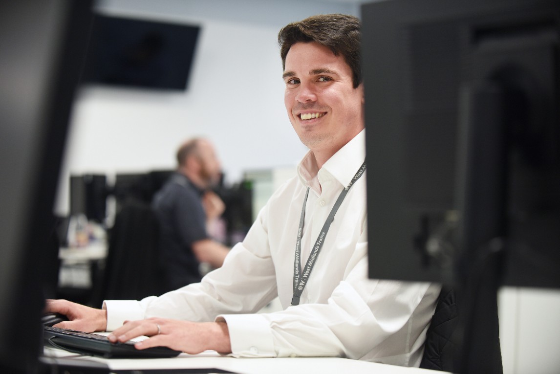 Smiling man in front of the computer monitor