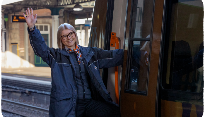 Female conductor standing by a WMR train