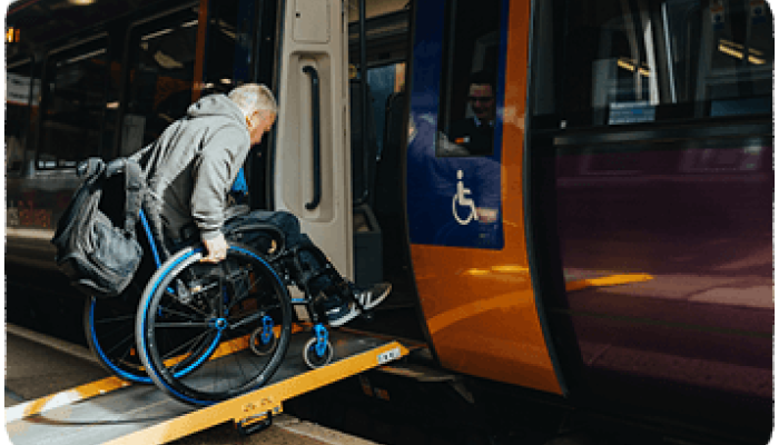 Wheelchair assisted passenger using a ramp to get onto the train
