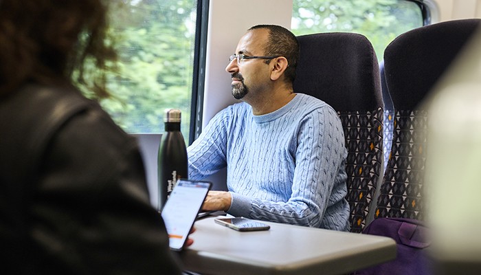 Man sitting on a West Midlands Railway train