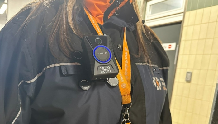 A member of WMR staff wearing a Body Worm Camera on a black jacket. The WMR logo is displayed on the jacket and an orange lanyard is worn. 
