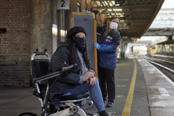 Woman in wheelchair waiting for train.