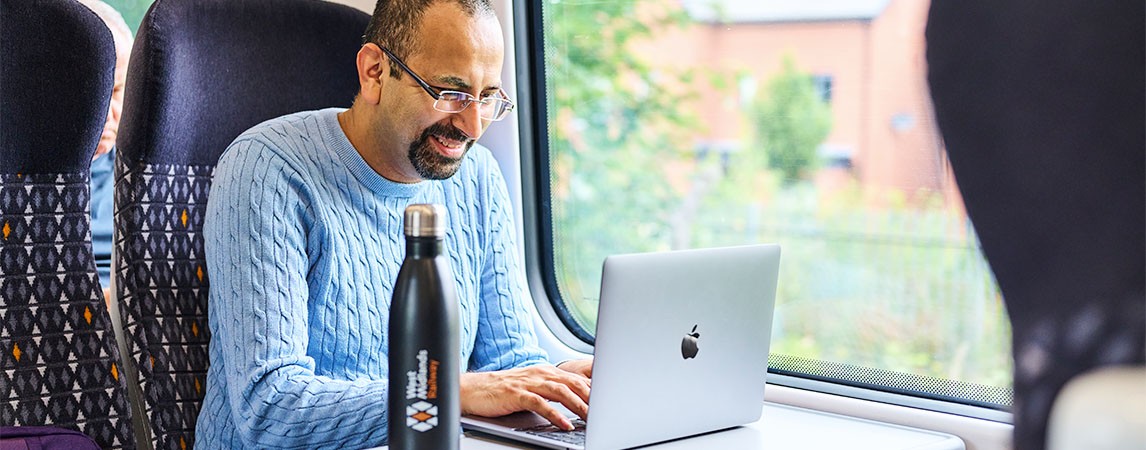Passenger working on his laptop on a train